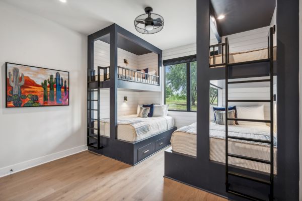 The image shows a modern bedroom with two bunk beds, a ceiling fan, wood flooring, and a colorful cactus painting on the wall.